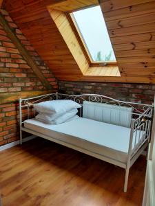 a metal bed in a room with a window at Dom Gościnny Magiczna Stodółka in Osiecznica