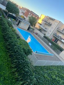 a large blue swimming pool next to a hedge at Nid d'Amour in Strasbourg