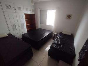 ein kleines Zimmer mit 2 Betten und einem Fenster in der Unterkunft Apartamento em Praia Grande - Frente ao Mar in Praia Grande