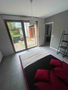 Un dormitorio con una cama con almohadas rojas y una ventana en Ô calme Cosy - Jardins et Villes - Expérience Unique - Wifi Gratuit - Parking gratuite en Grenoble