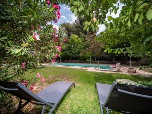 a yard with two chairs and a swimming pool at Appartements tout équipés climatisés Piscine et Jardin in Marseille