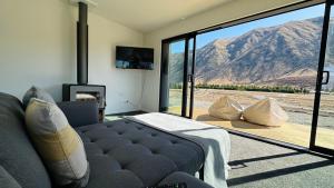 a living room with a couch and a view of a mountain at Manuka Vista in Twizel