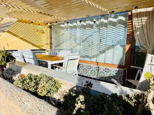 a patio with white chairs and a table and a table and chairs at Aquí Ahora San José in San José