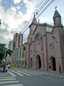 a large brick church with a clock tower on a street at GRAN APARTAESTUDIO EN BOSTON - MEDELLIN in Medellín