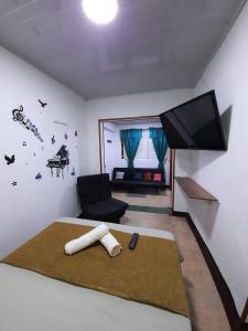 een slaapkamer met een bed, een televisie en een stoel bij GRAN APARTAESTUDIO EN BOSTON - MEDELLIN in Medellín