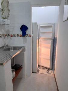 a kitchen with an open refrigerator and a sink at GRAN APARTAESTUDIO EN BOSTON - MEDELLIN in Medellín