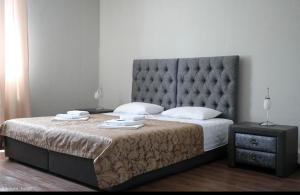 1 dormitorio con 1 cama grande y cabecero grande en Amore Hotel, en Gudauta