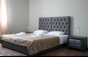 a bedroom with a large bed with a large headboard at Amore Hotel in Gudauta