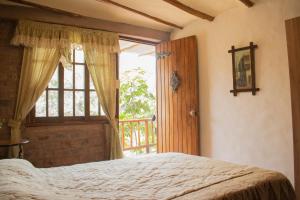 ein Schlafzimmer mit einem Bett und einem großen Fenster in der Unterkunft Hacienda Santa María de Cieneguilla in Cieneguilla