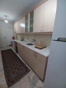 una cucina con armadi bianchi, lavandino e frigorifero di Appartement 2 eme Etage Ortaköy no 4 a Istanbul