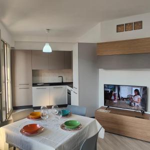 a kitchen with a table with plates and wine glasses at MareVivo Marzamemi in Marzamemi