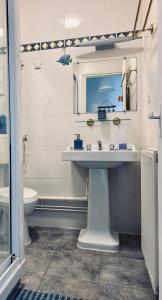 La salle de bains est pourvue d'un lavabo et de toilettes. dans l'établissement Le Gîte du Phare vue sur mer, à Cayeux-sur-Mer