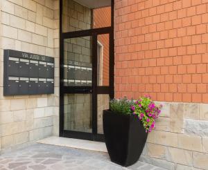 a black planter on the side of a building with flowers at Dolce Casa Only Adults B&B in San Lazzaro di Savena