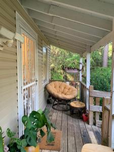 a porch with a chair and a bench on it at Little Covington Home in Covington