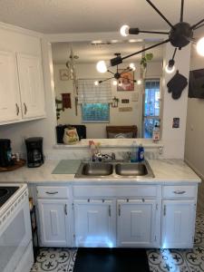 una cocina con armarios blancos y fregadero en Little Covington Home en Covington