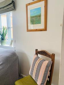 a bedroom with a bed and a chair with a picture on the wall at The Town House in Aylsham