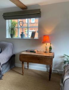 a table with a lamp on it in a bedroom at The Town House in Aylsham
