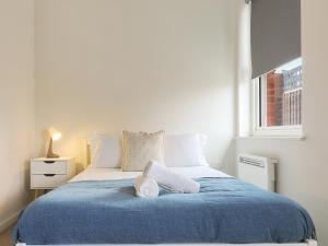 謝菲爾德的住宿－Luxury Modern 2-Bed Apartment - City Centre, FREE Netflix, Pet Friendly，一间卧室配有一张带蓝色毯子的大床