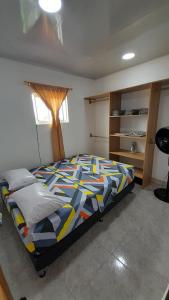 ein Schlafzimmer mit einem Bett mit einer bunten Bettdecke in der Unterkunft Apto Hogar Dulce Hogar ARBOLETES in Arboletes