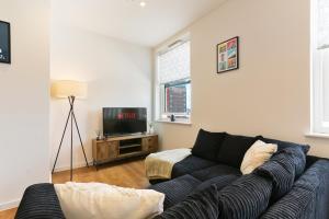 a living room with a blue couch and a tv at Luxury Modern 2-Bed Apartment - City Centre, FREE Netflix, Pet Friendly in Sheffield