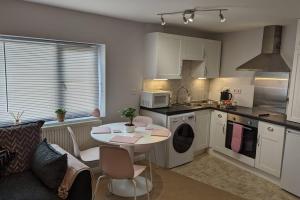 牛津的住宿－Turtle Dove Apartment，厨房以及带桌子和沙发的客厅。
