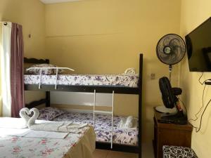 2 literas en una habitación con ventilador en Cantinho Casa Grande, en Beberibe