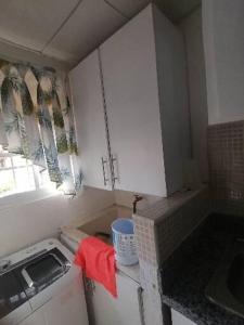 een keuken met witte kasten en een wastafel bij Apartamento K de 3 a 5 Minutos de la embajada in Pantoja