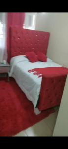 a red bed with a red headboard in a room at Apartamento K de 3 a 5 Minutos de la embajada in Pantoja