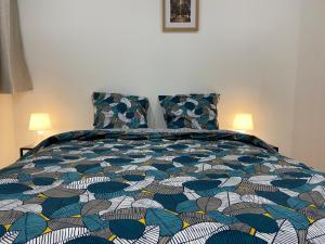 una camera da letto con un letto con un piumone colorato di La galerie, proche aéroport a Tillé