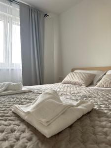 uma cama com um cobertor branco com uma janela em Luxury Penthouse with seaview and parking em Zadar