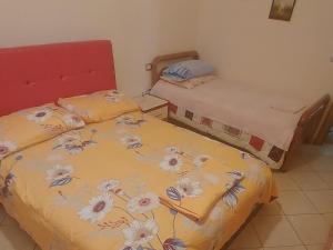 a bedroom with two beds with flowers on the sheets at Apartment Juri in Vlorë