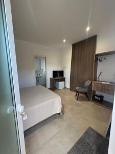 a bedroom with a bed and a chair and a television at PoolSide in Irsina