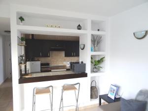 kuchnia z blatem i 2 krzesłami w pokoju w obiekcie Puerto Del Carmen - Apartment 5 - Las Palmeras 3 w Puerto del Carmen
