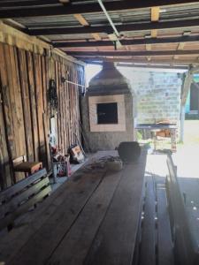 ein Wohnzimmer mit einem Holztisch und einem Kamin in der Unterkunft Pousada do bololo in Cidreira