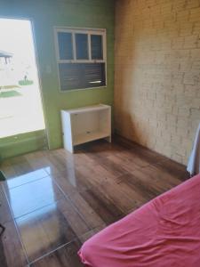 Zimmer mit einem Bett, einem Tisch und einem Fenster in der Unterkunft Pousada do bololo in Cidreira