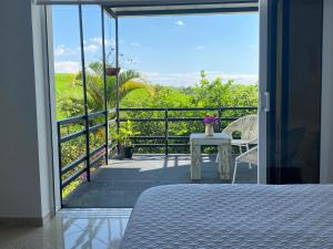 um quarto com uma cama e uma varanda com vista em Hotel Casa Natura em Pereira