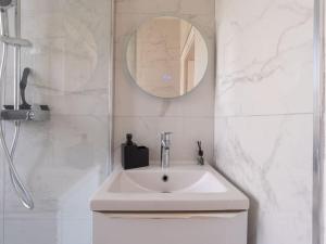 a white bathroom with a sink and a mirror at Appartement pour 8 personnes près de Disney & Paris in Chanteloup-en-Brie