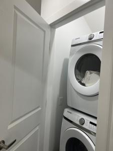 a laundry room with a washing machine and a door at Newly built one bedroom 2 bed in Calgary