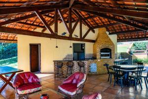eine Terrasse mit einem Tisch, Stühlen und einem Kamin in der Unterkunft Casa coração serra Guaramiranga in Guaramiranga