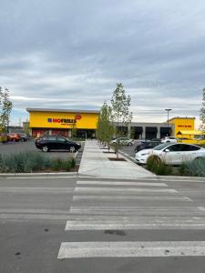 una tienda amarilla con coches estacionados en un estacionamiento en Newly built one bedroom 2 bed, en Calgary