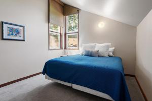 a bedroom with a blue bed and a window at 26 Mountain View Lodge - Meredith Lodging in Bend