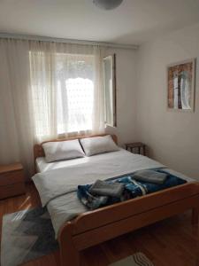a bedroom with a large bed with a window at Vila Vera Vrsac in Vršac