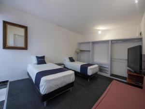 a hotel room with two beds and a flat screen tv at Casa Tanimisha in Mexico City