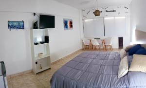 1 dormitorio con 1 cama y 1 mesa con sillas en Amar el mar en Puerto Madryn