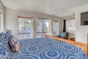 a bedroom with a blue and white bed and windows at Neskowin Lookout in Neskowin