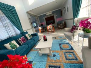 a living room with a blue couch and a table at lot 1217 large private villa with pool A’Famosa golf resort melayu in Kampong Alor Gajah