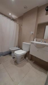 a bathroom with a toilet and a sink at Amplio Estudio de lujo con balcon y parrilla in Puerto Madryn