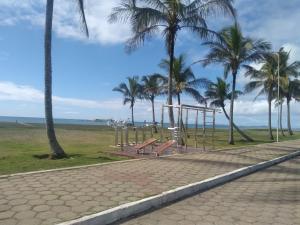 a park with benches and palm trees and the ocean at Frente a Praia. Ótima casa barra de são João Rio das ostras,fino acabamento in Barra de São João +17 photos