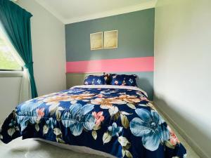 een slaapkamer met een bed met een kleurrijke sprei bij lot 1217 large private villa with pool A’Famosa golf resort melayu in Kampong Alor Gajah