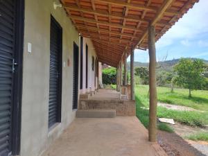 a porch of a house with a wooden roof at camping toca raul in São Thomé das Letras